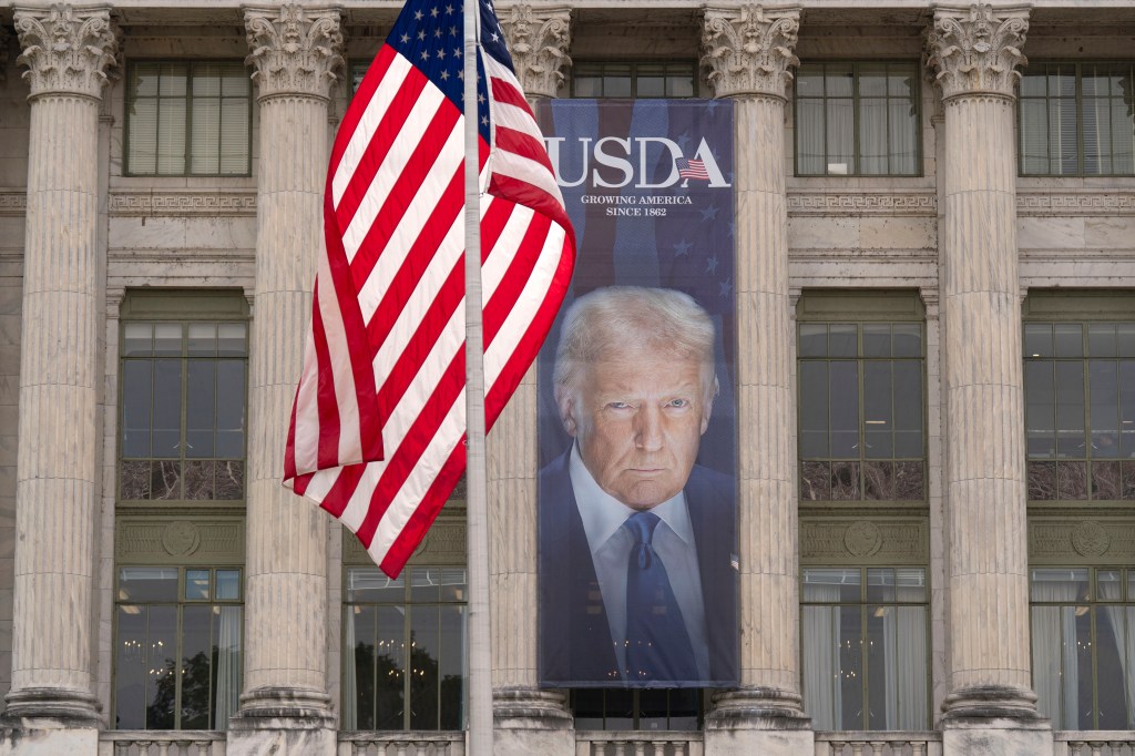 Banner of Donald Trump at the USDA building with an American flag.