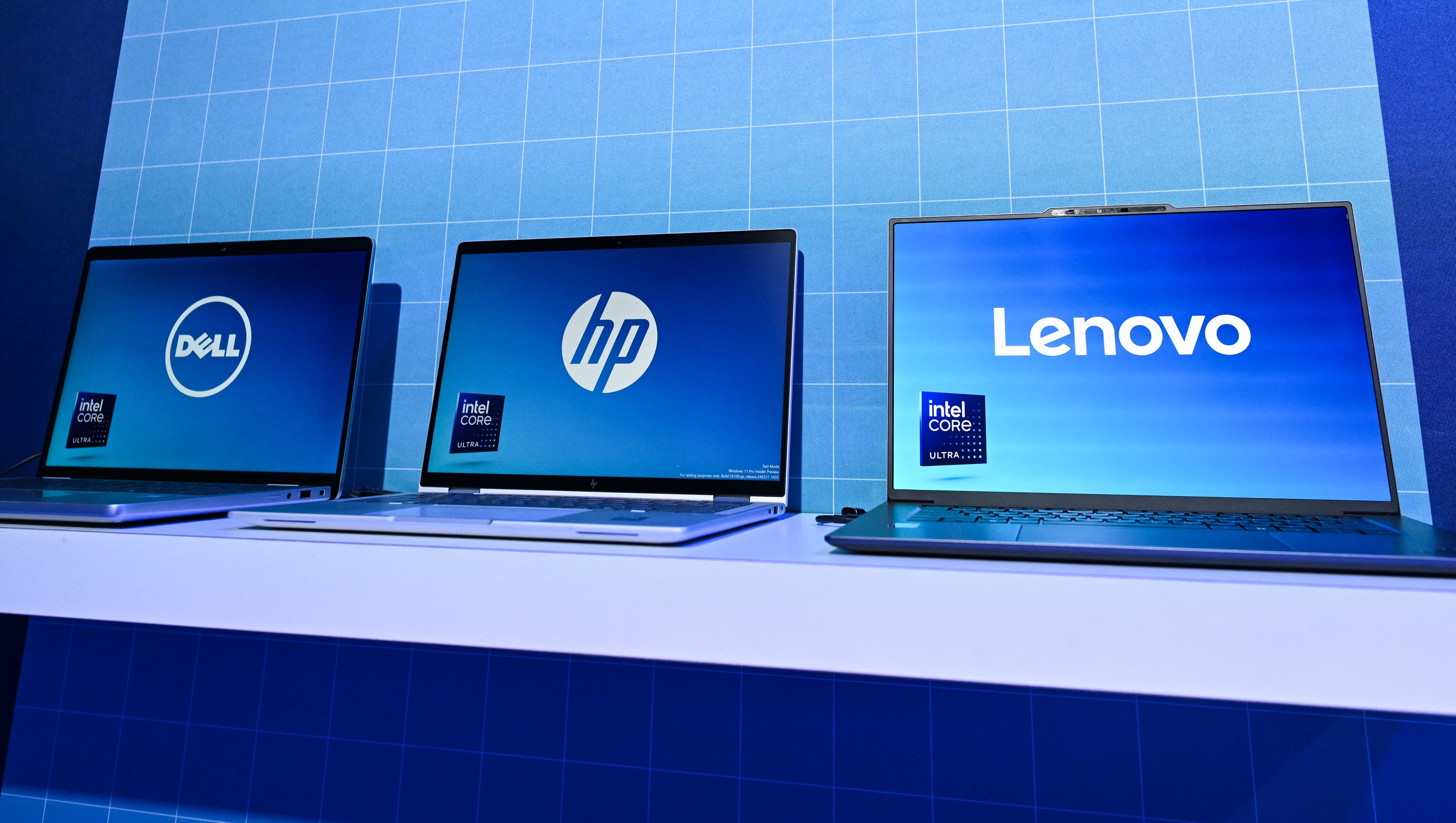 Dell, HP, and Lenovo laptops lined up in a blue setting