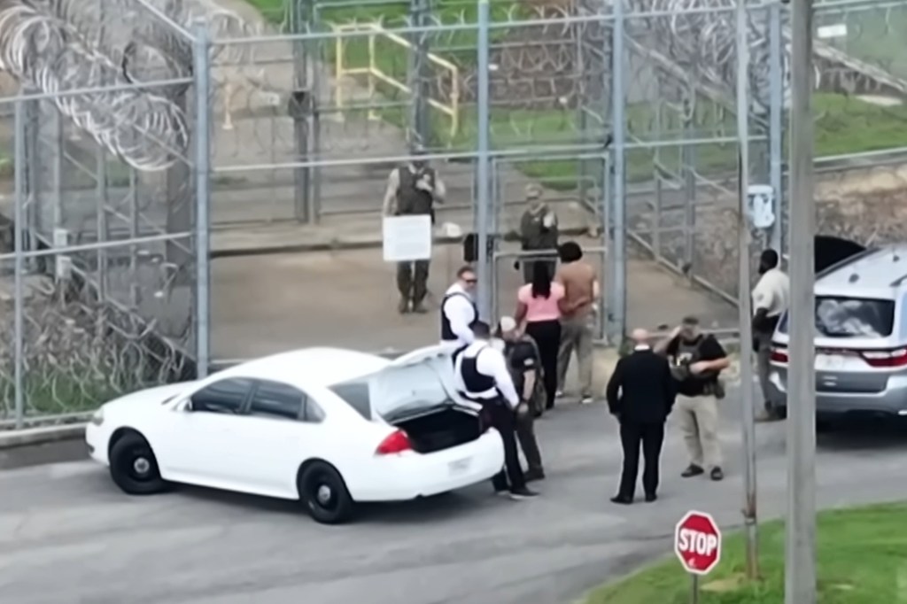 Ghislaine Maxwell is escorted from a car into a fenced area at the FCI Tallahassee complex on July 24, 2025.