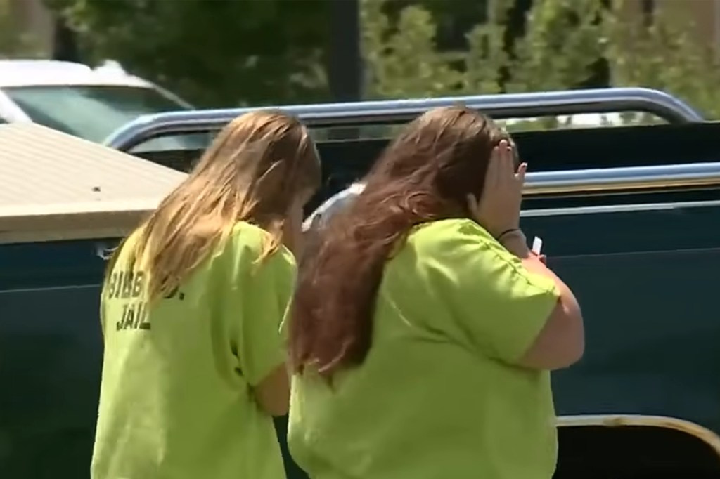 Two women in lime green jail uniforms.