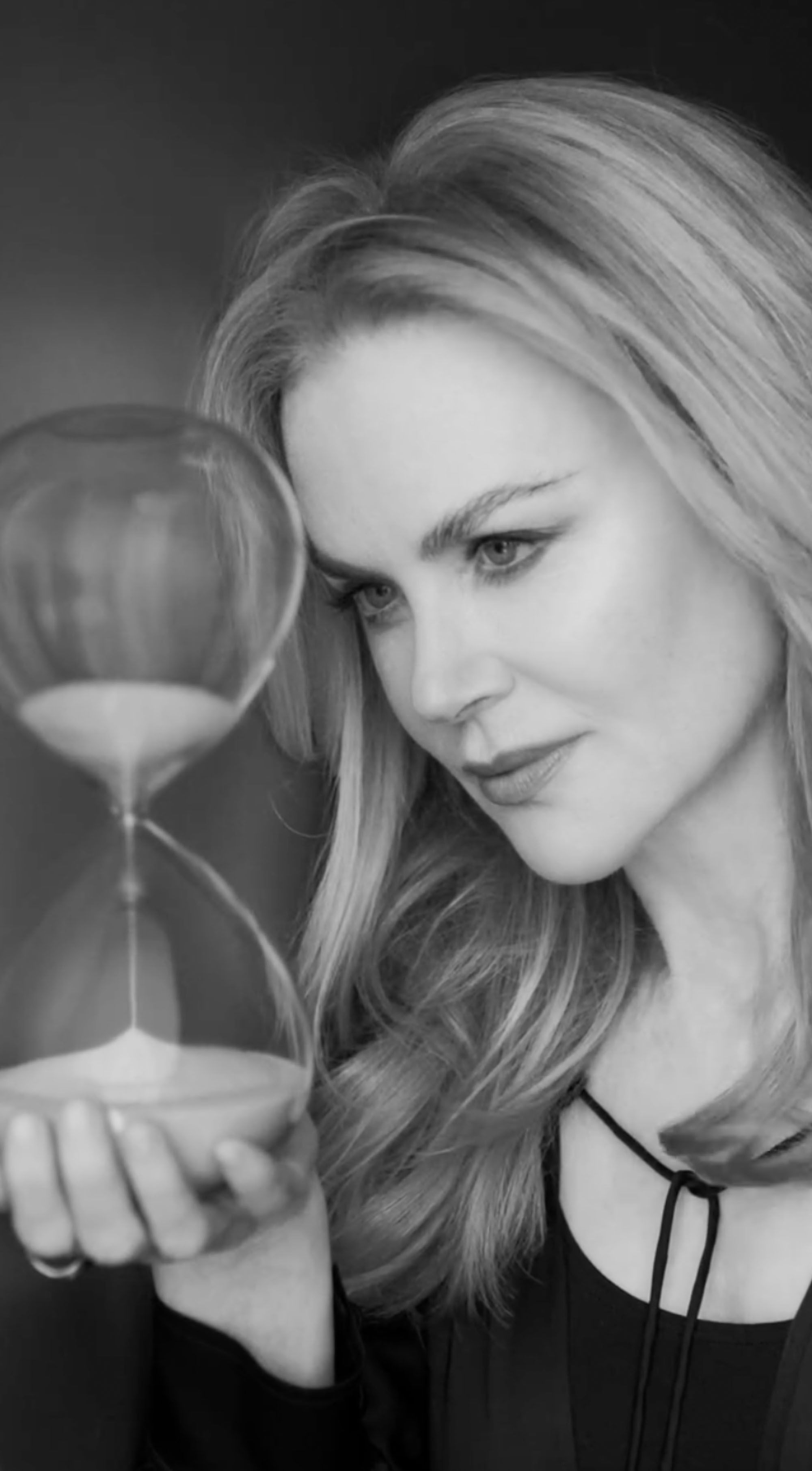 Nicole Kidman looks at an hourglass. 