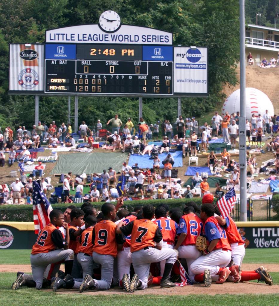 Little League World Series players huddle together on the field.