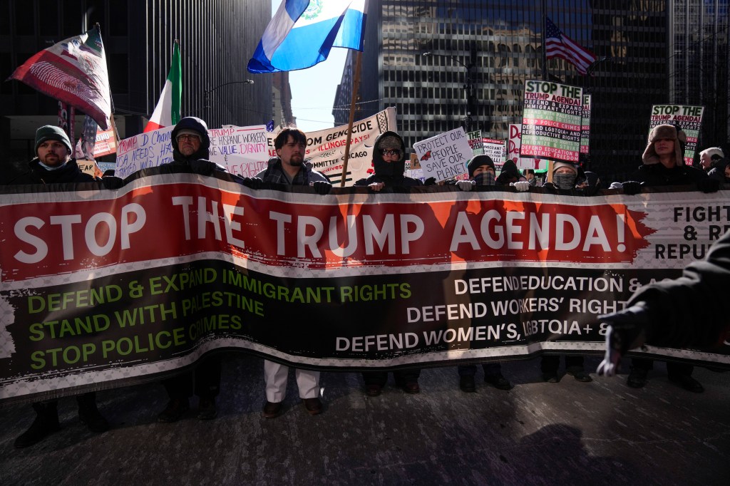 Protesters hold up a sign opposing President Trump outside Trump Tower in Chicago during a rally on Jan. 20, 2025.