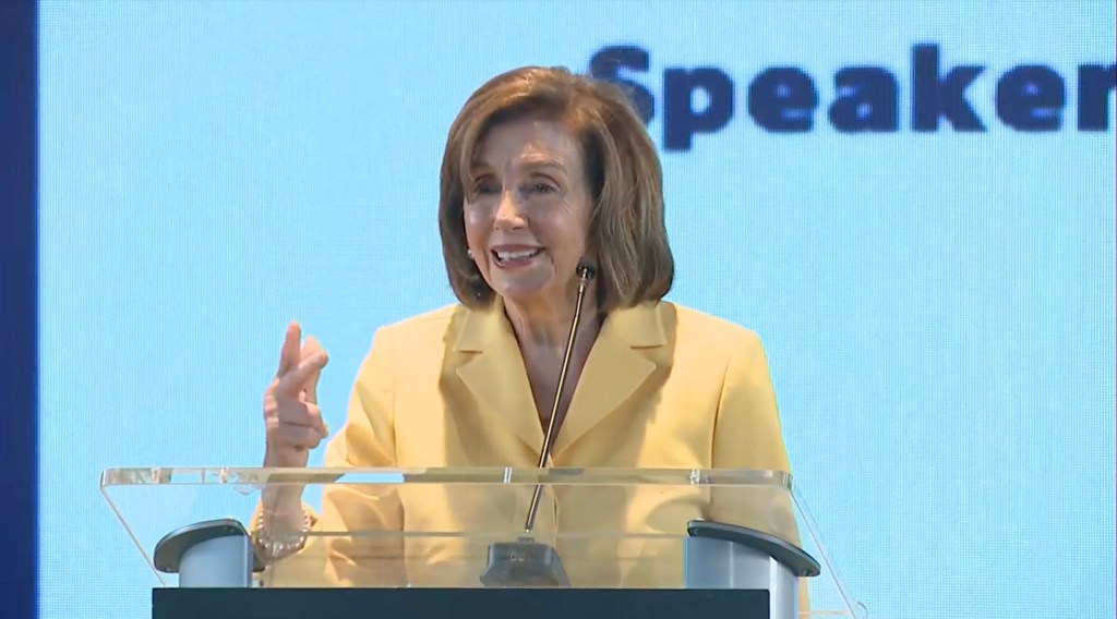 Nancy Pelosi speaking at a podium.