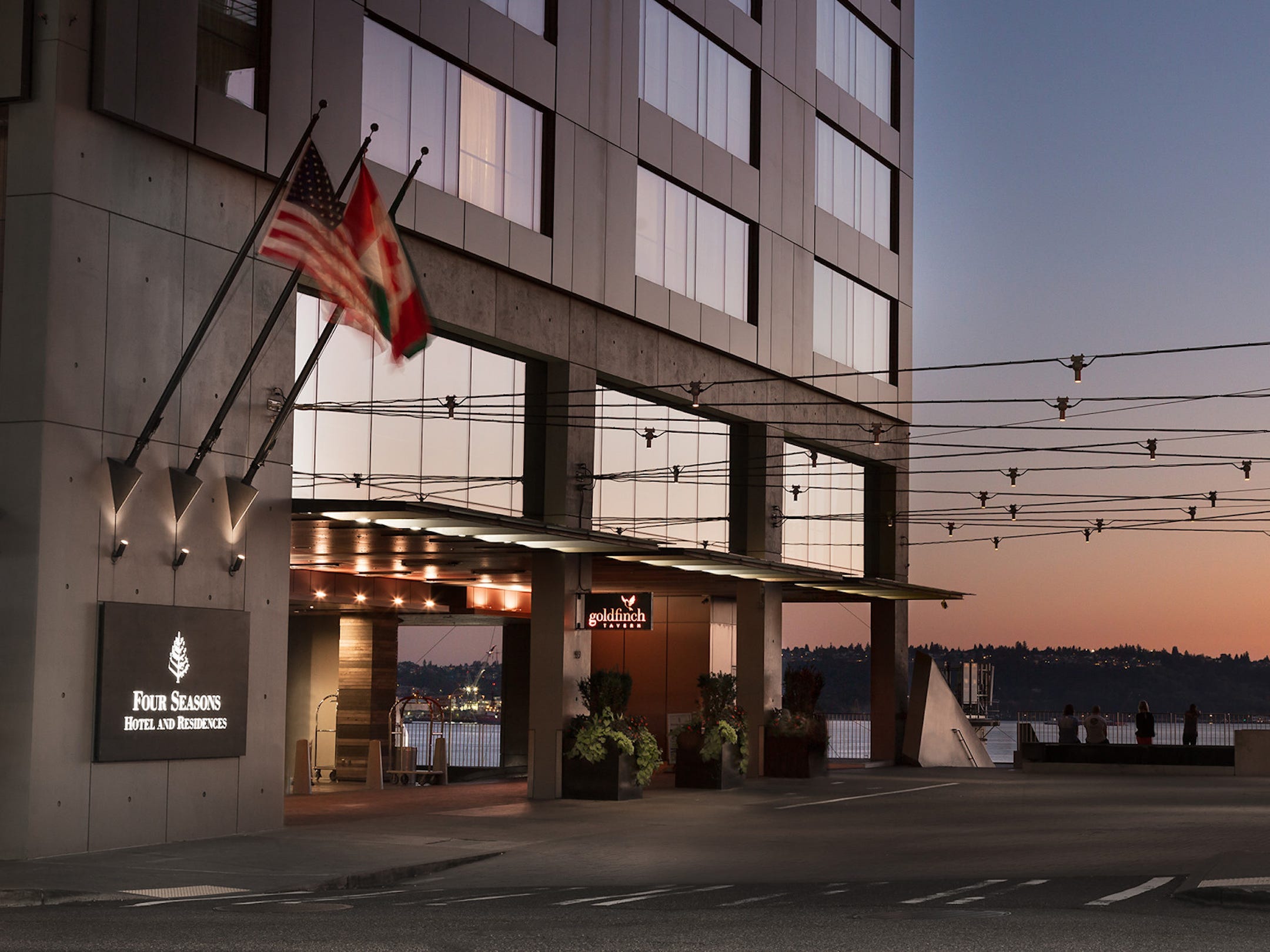 The exterior of the Four Seasons Seattle at sunset with a ferris wheel in the background