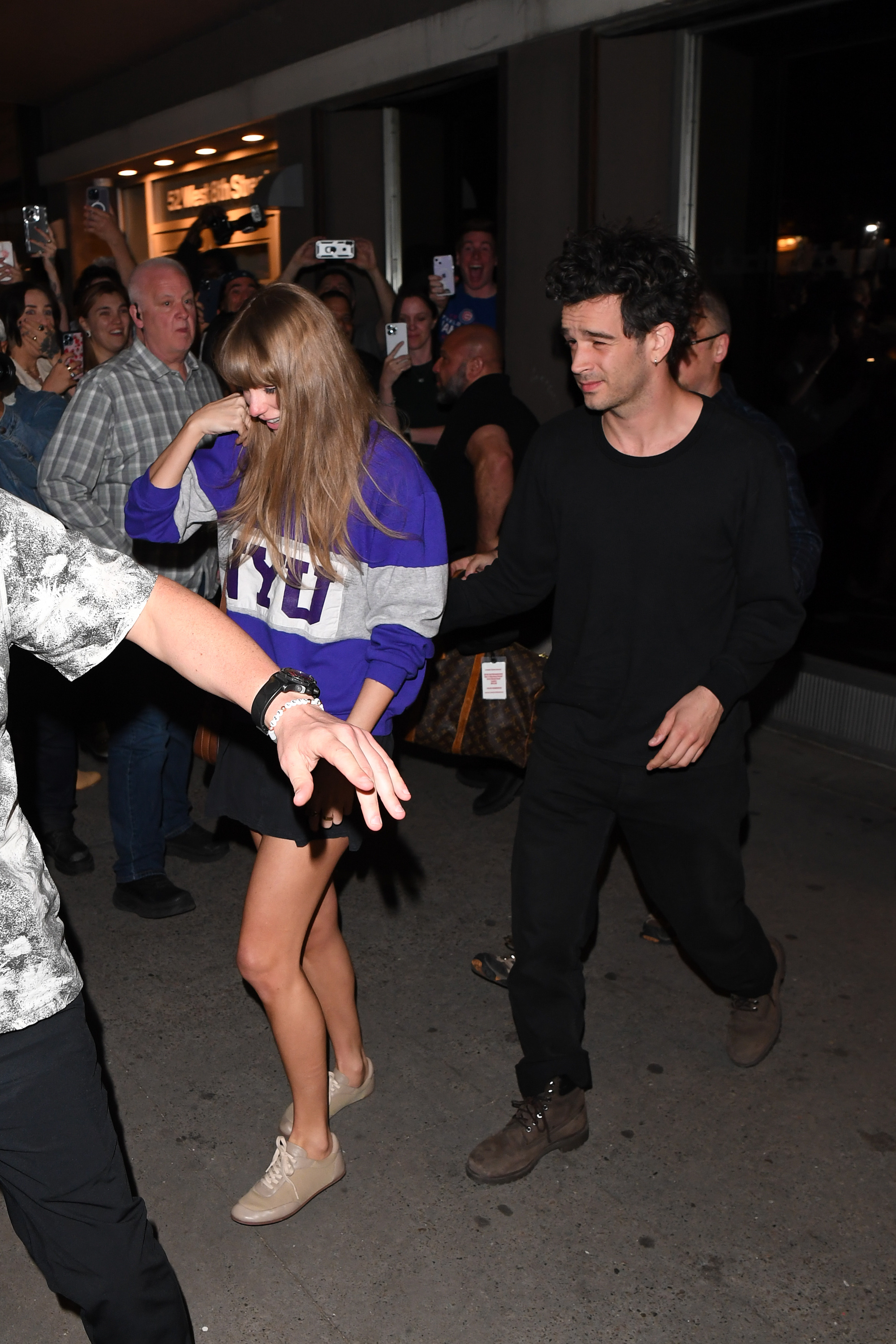 Taylor Swift and Matty Healy out at night. 