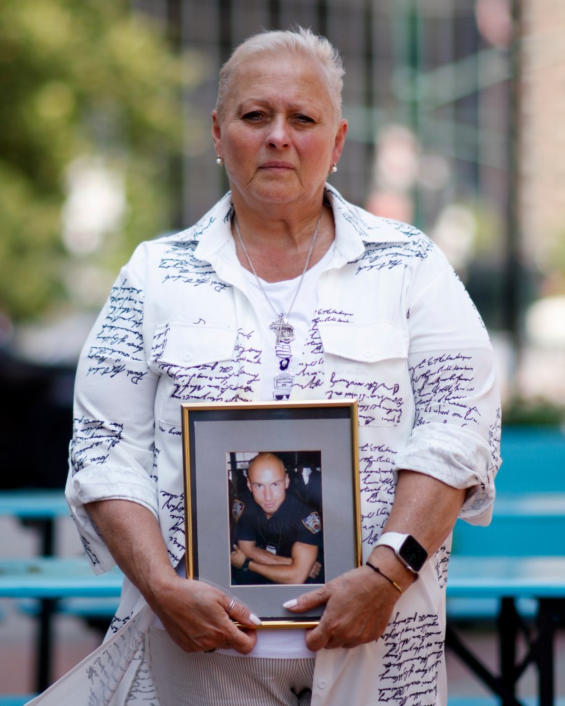 Woman holding framed photo of police officer.