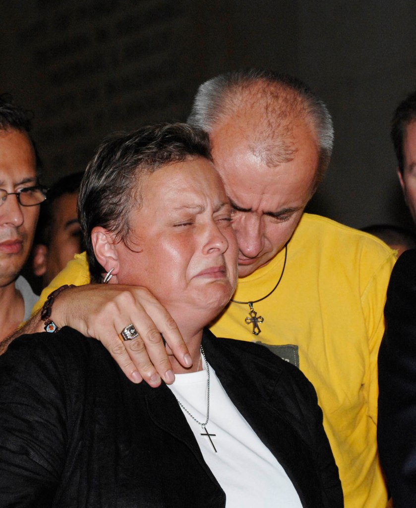 Parents of slain NYPD officer Russel Timoshenko embrace at a press conference.