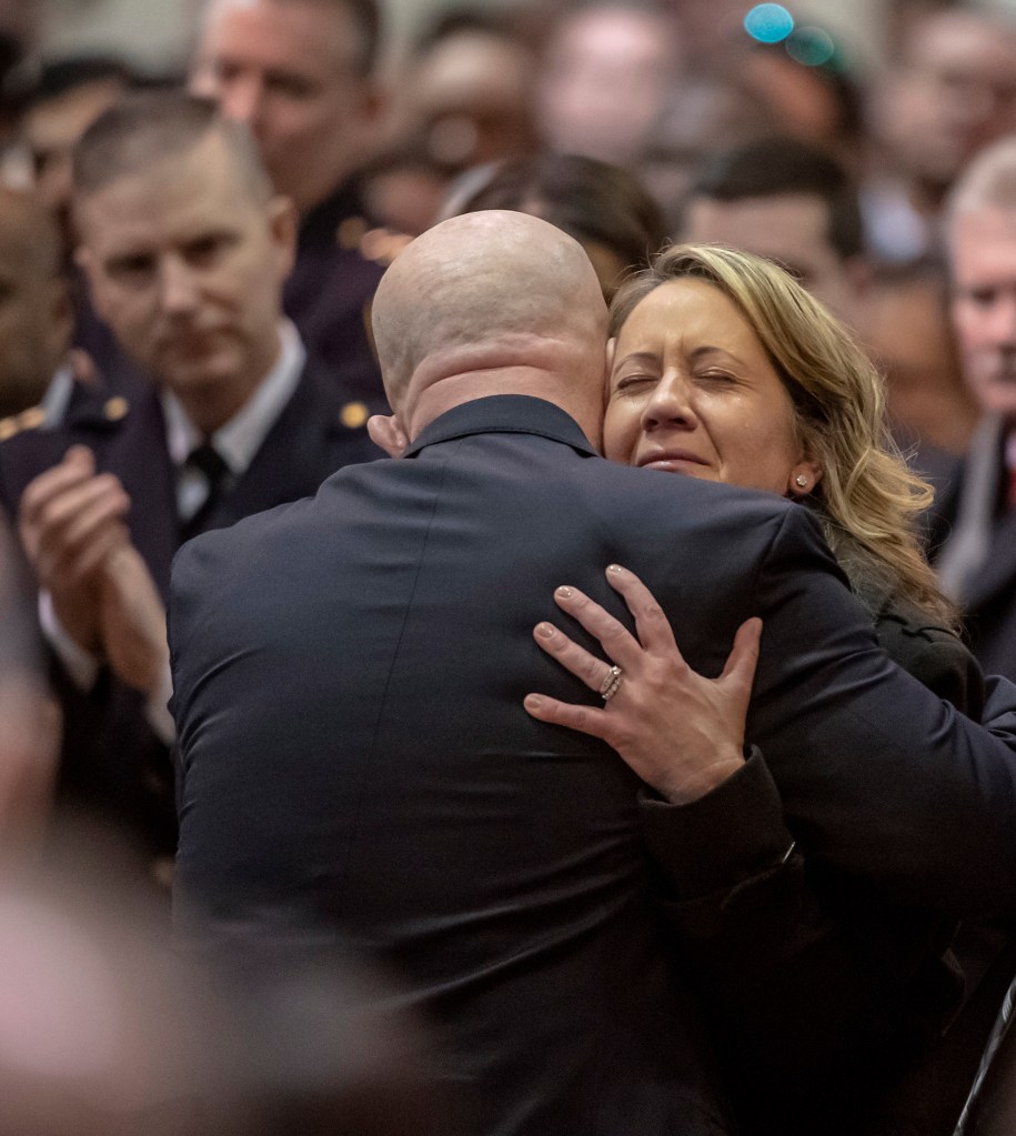 A woman embracing a man at a funeral.