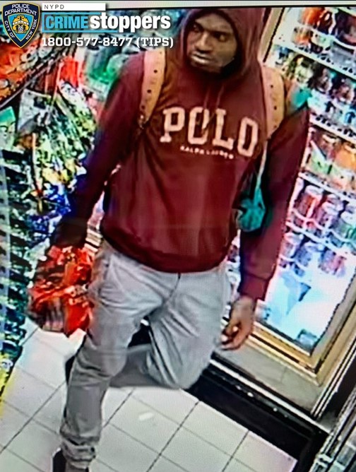 Surveillance image of arson suspect wearing a maroon Polo sweatshirt, gray pants, and a light brown backpack.