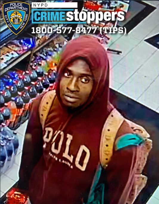 Surveillance image of arson suspect wearing a maroon Polo sweatshirt and tan backpack.