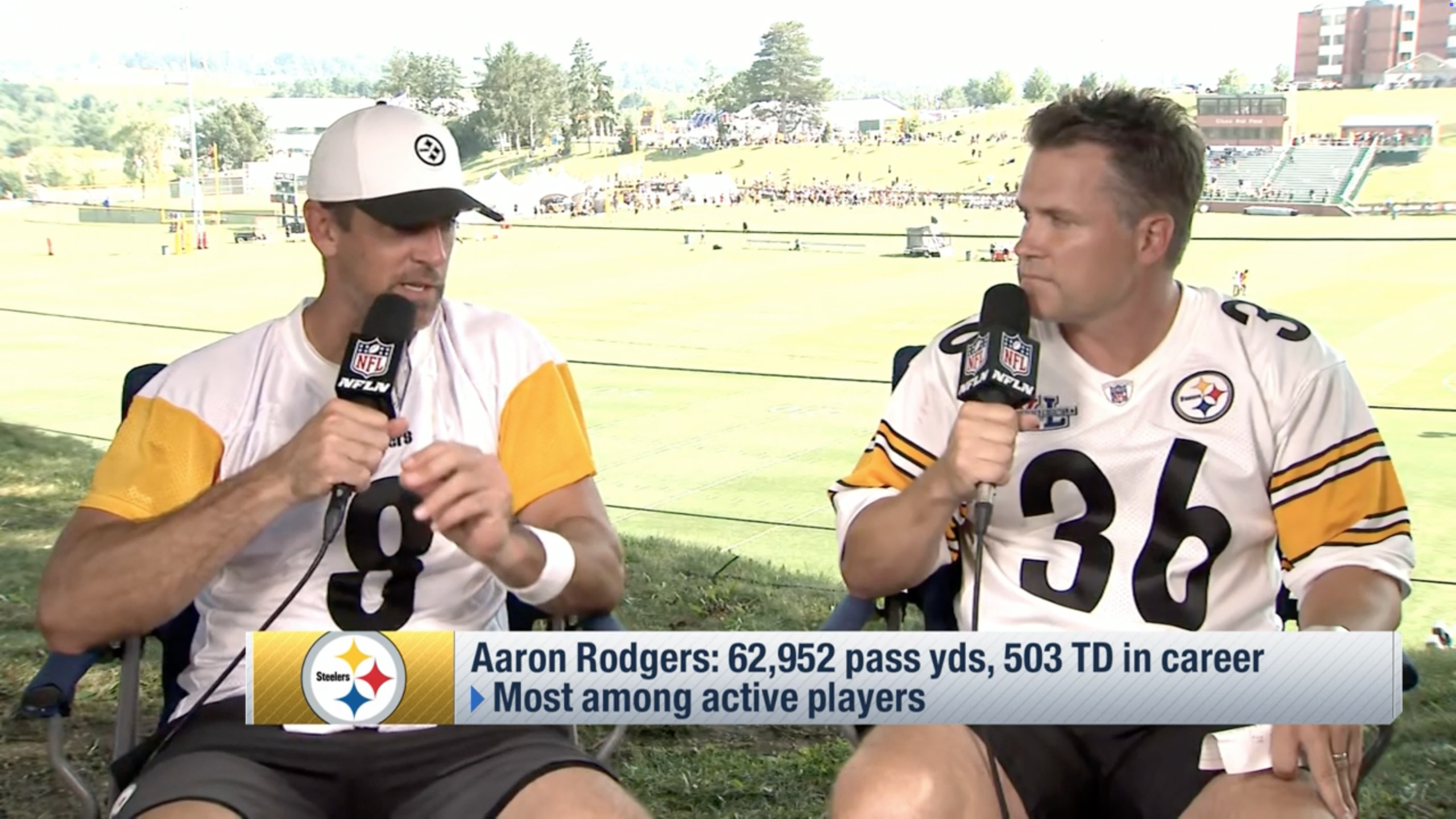 Aaron Rodgers speaks into a microphone during an outdoor press conference. 