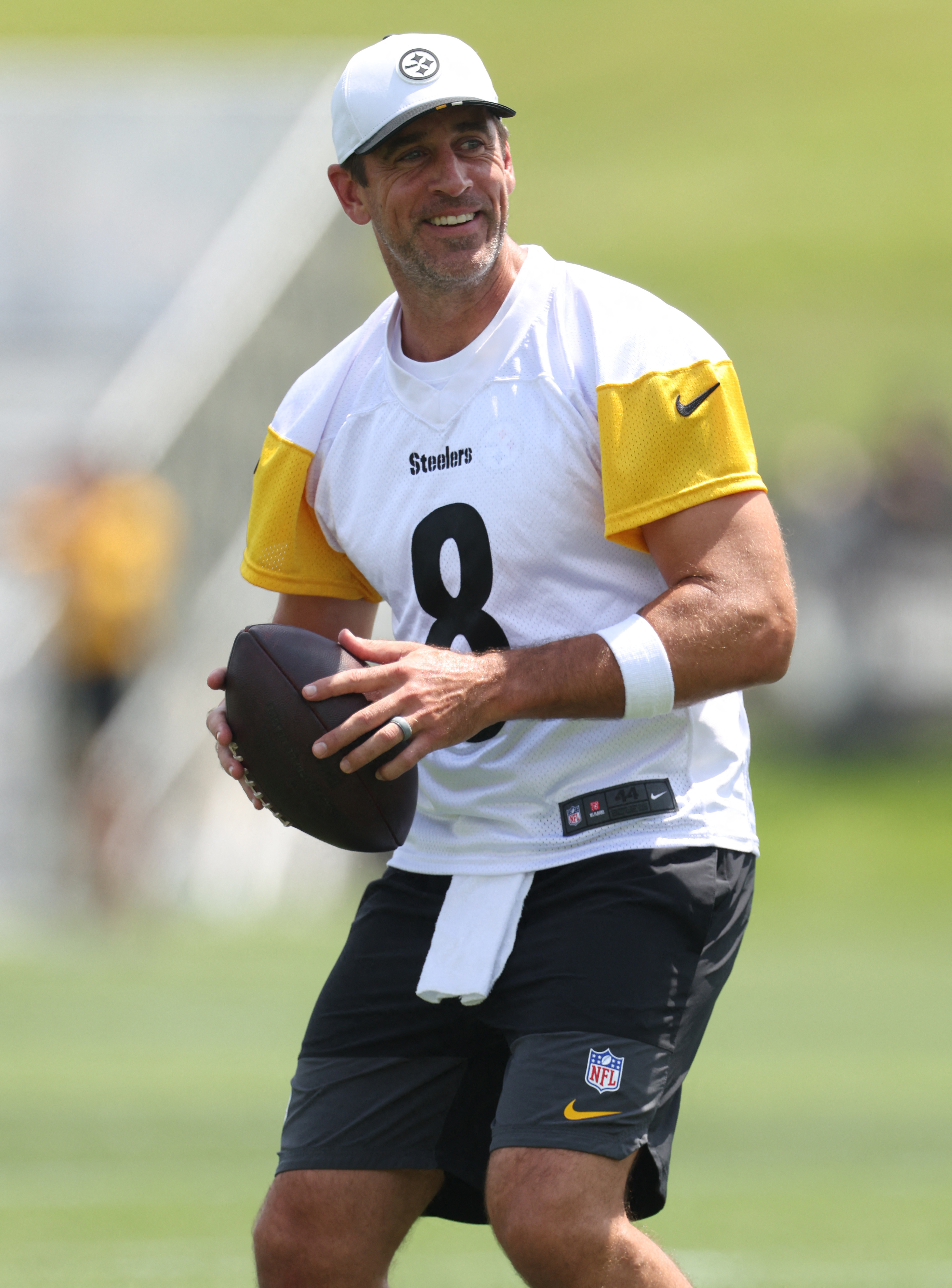 Aaron Rodgers holds a football. 