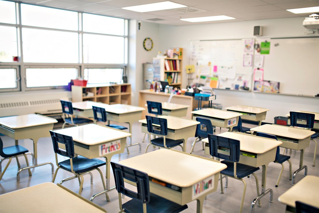Empty daycare classroom with desks and chairs.