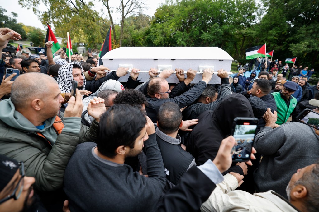 Mourners carrying a coffin at a funeral.