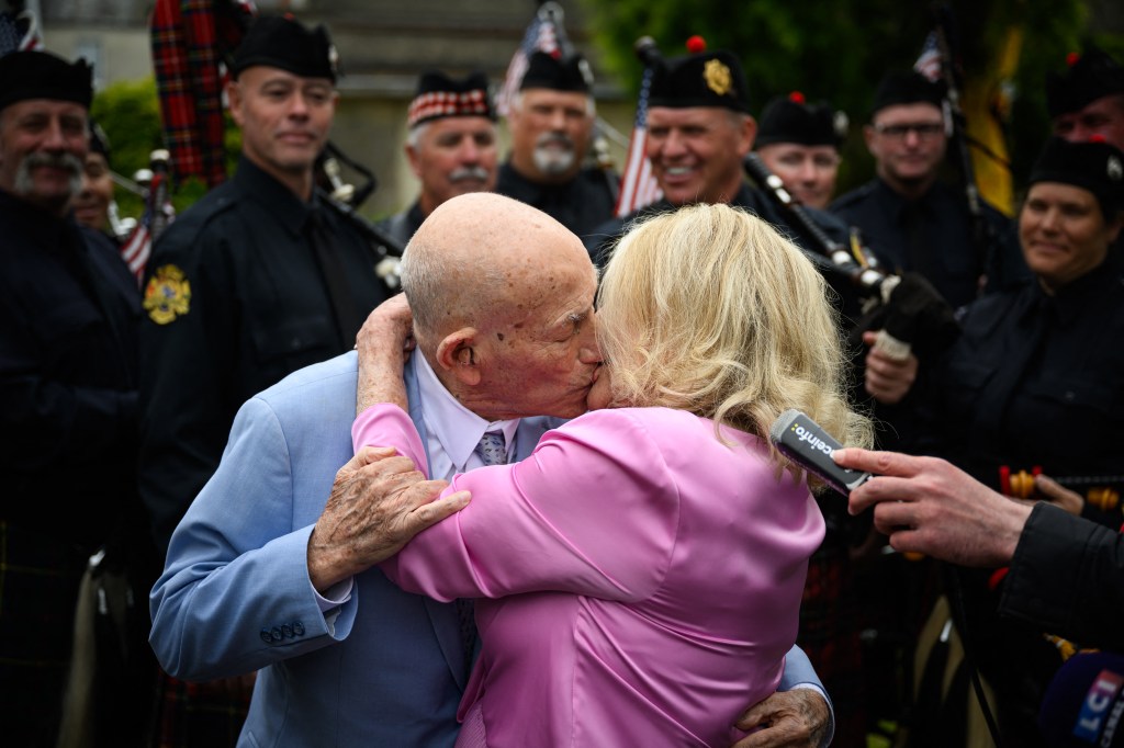 Newlyweds, a WWII veteran and his bride, kiss at their wedding.