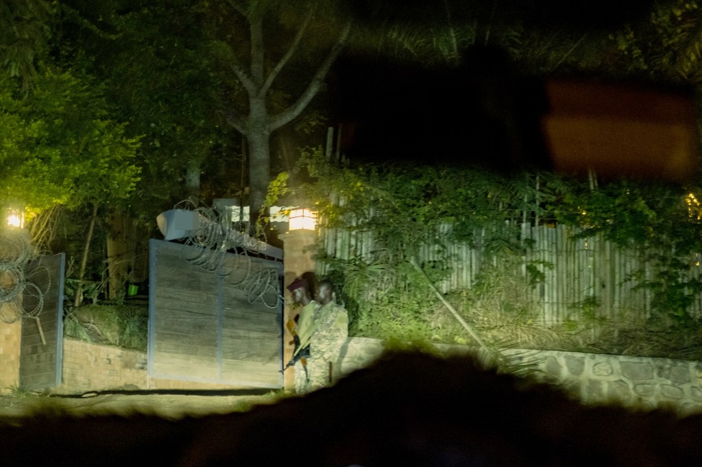 Nighttime photo of two soldiers guarding a gate.