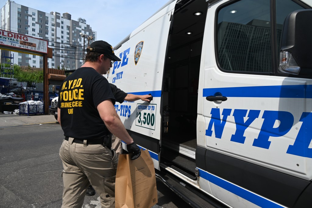 NYPD crime scene investigator placing evidence in a vehicle.