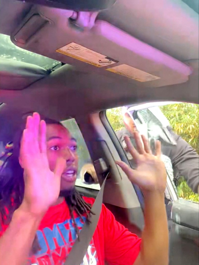 William McNeil Jr. puts his hands up as police breach his car during the traffic stop.