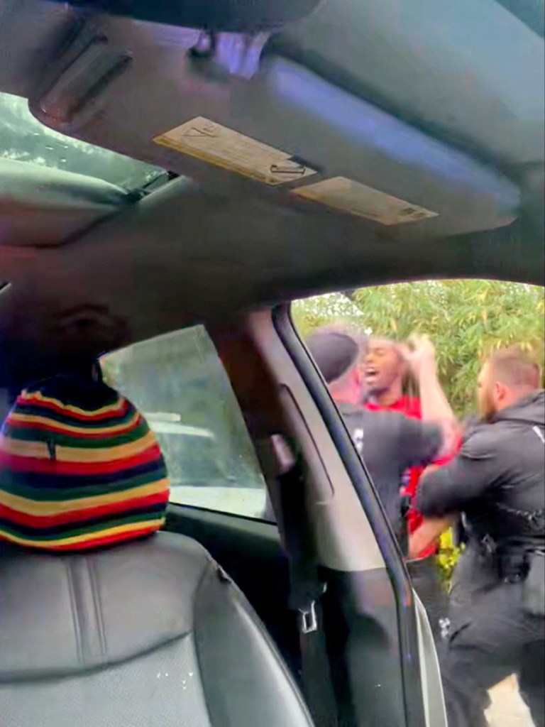 McNeil is detained by police outside his car during the traffic stop.