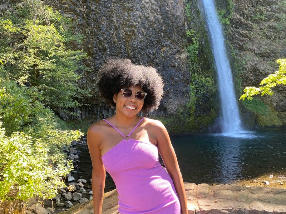 The writer in front of a waterfall in Oregon.