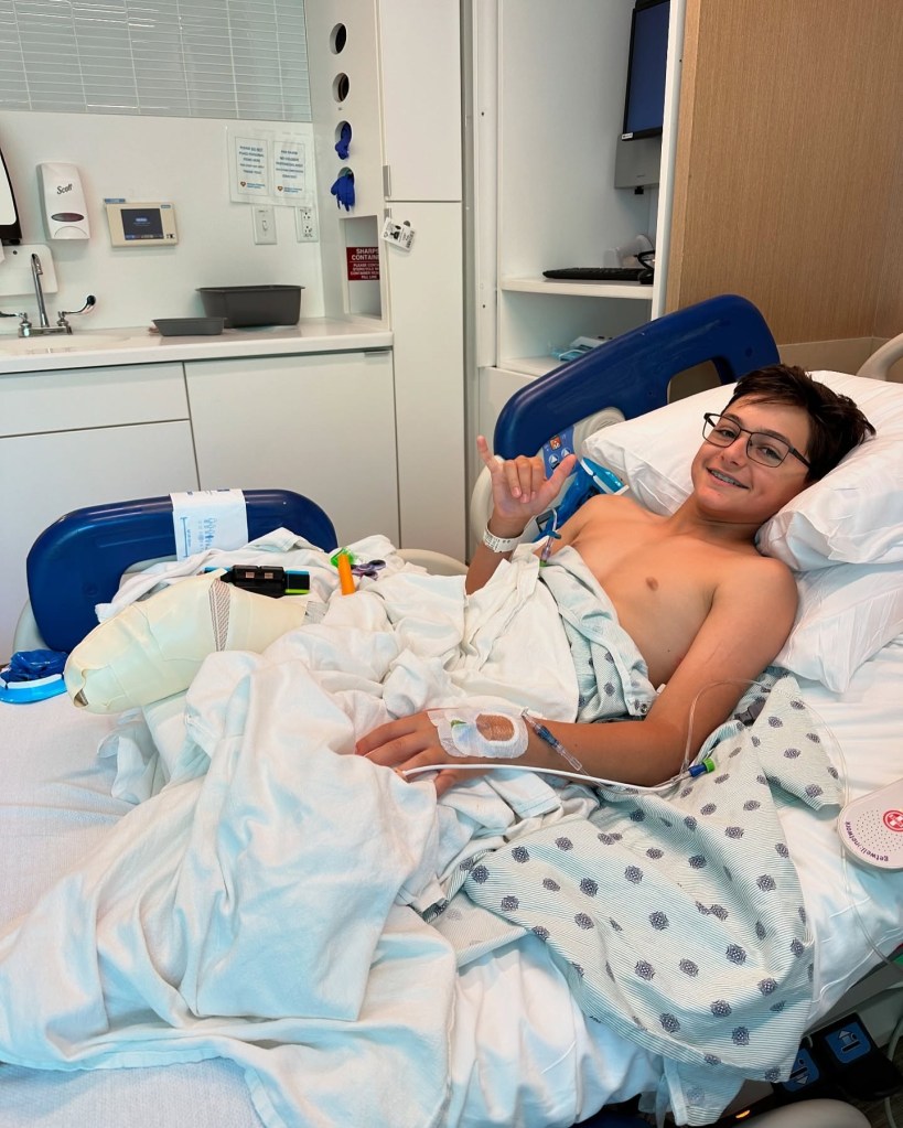 Smiling boy in hospital bed recovering from shark attack.