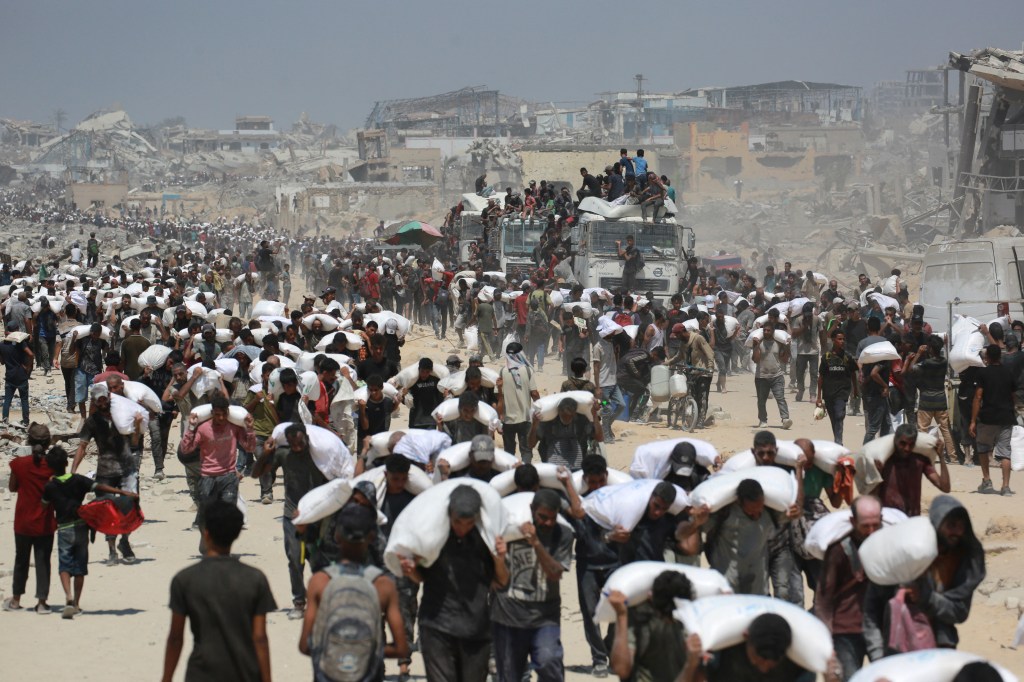 People carrying sacks of flour in war-torn Gaza.