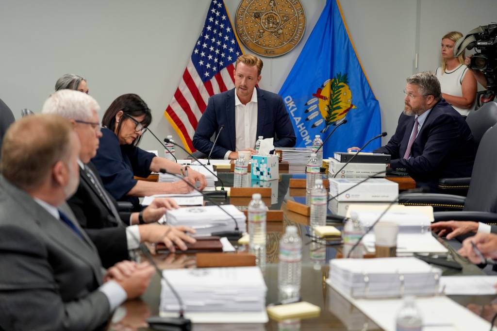 A group of people sitting around a table reviewing documents.