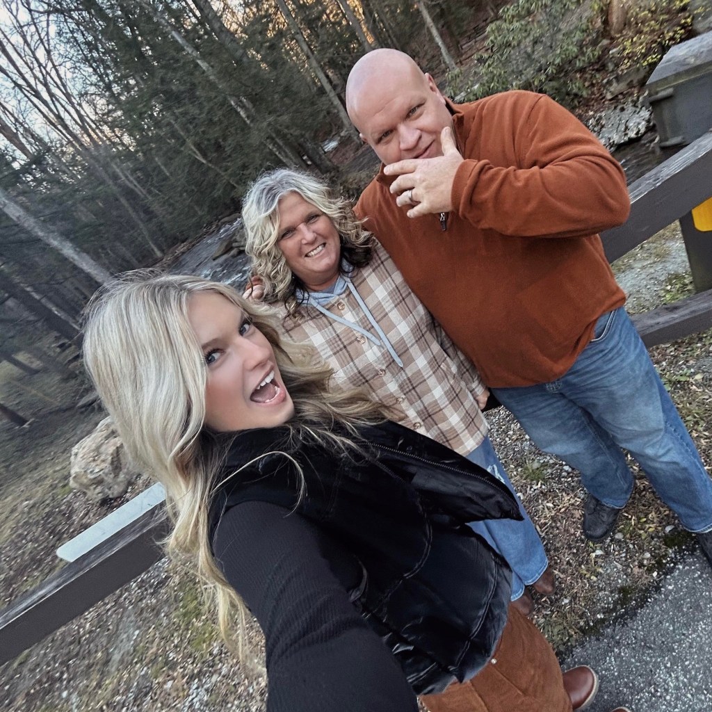 Family selfie in a wooded area.