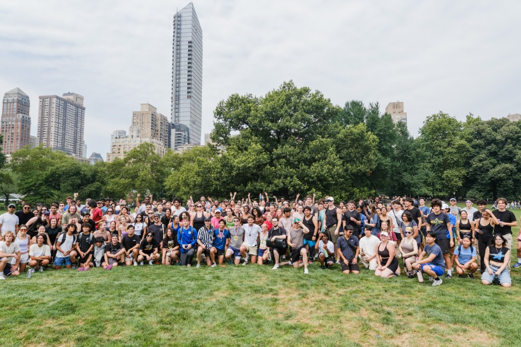 Large group of people posing for a photo in a park.