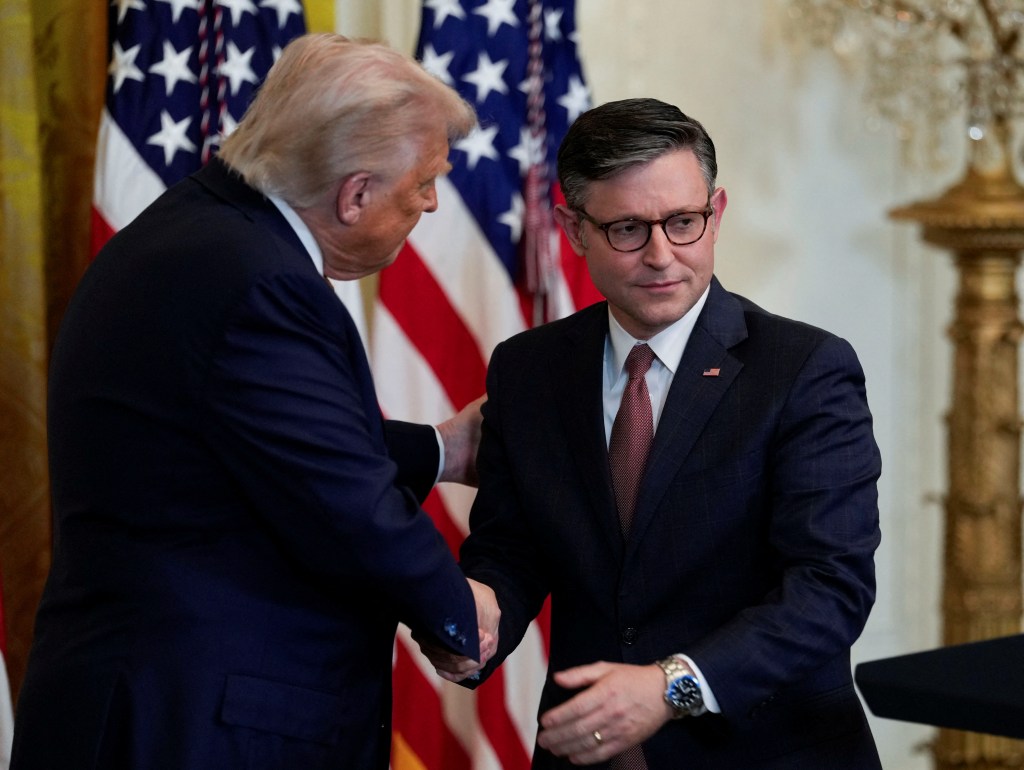 Trump shakes hands with U.S. House Speaker Mike Johnson as he hosts a dinner with Republican members of the U.S. Congress in the East Room of the White House in Washington, D.C., U.S., July 22, 2025. 