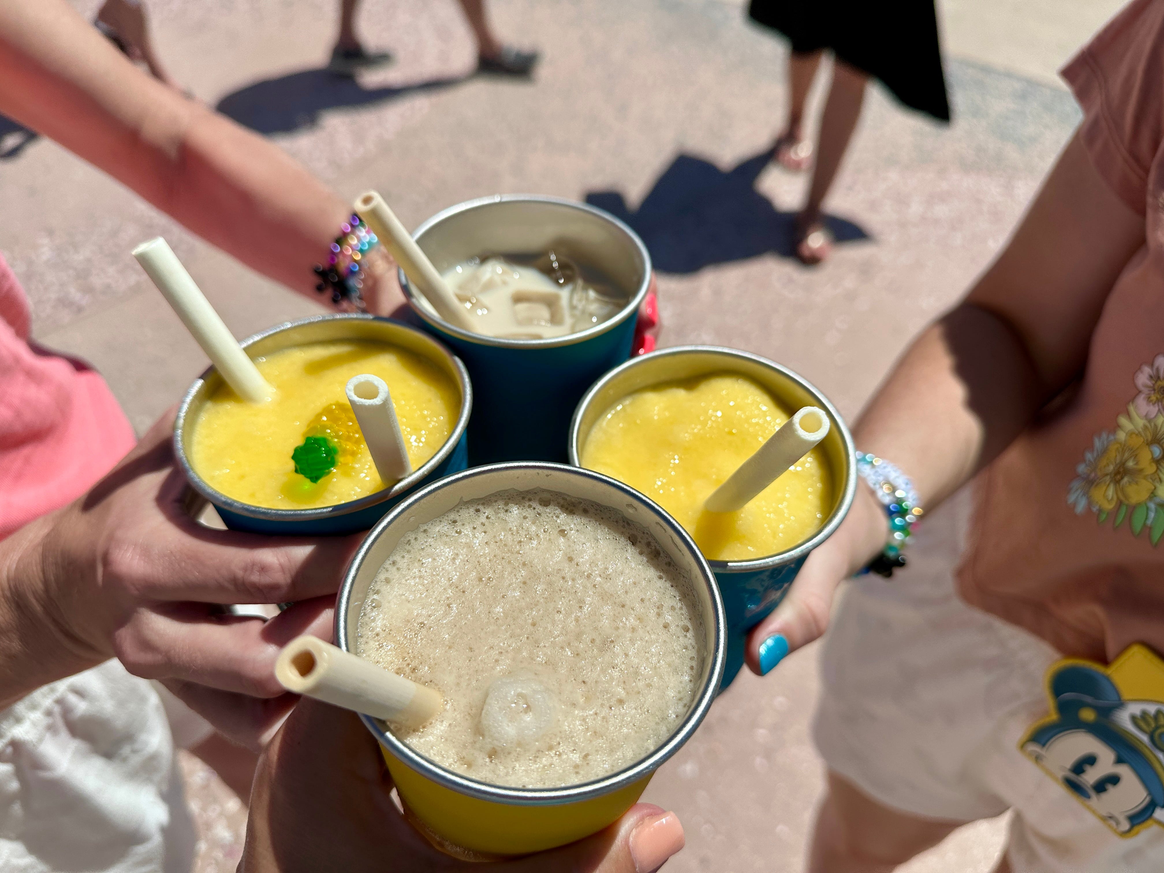 The author and three friends holding up drinks while taking a cruise.