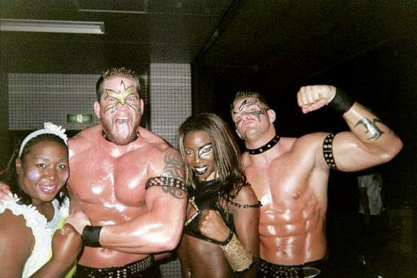 Photo of three wrestlers and a woman.