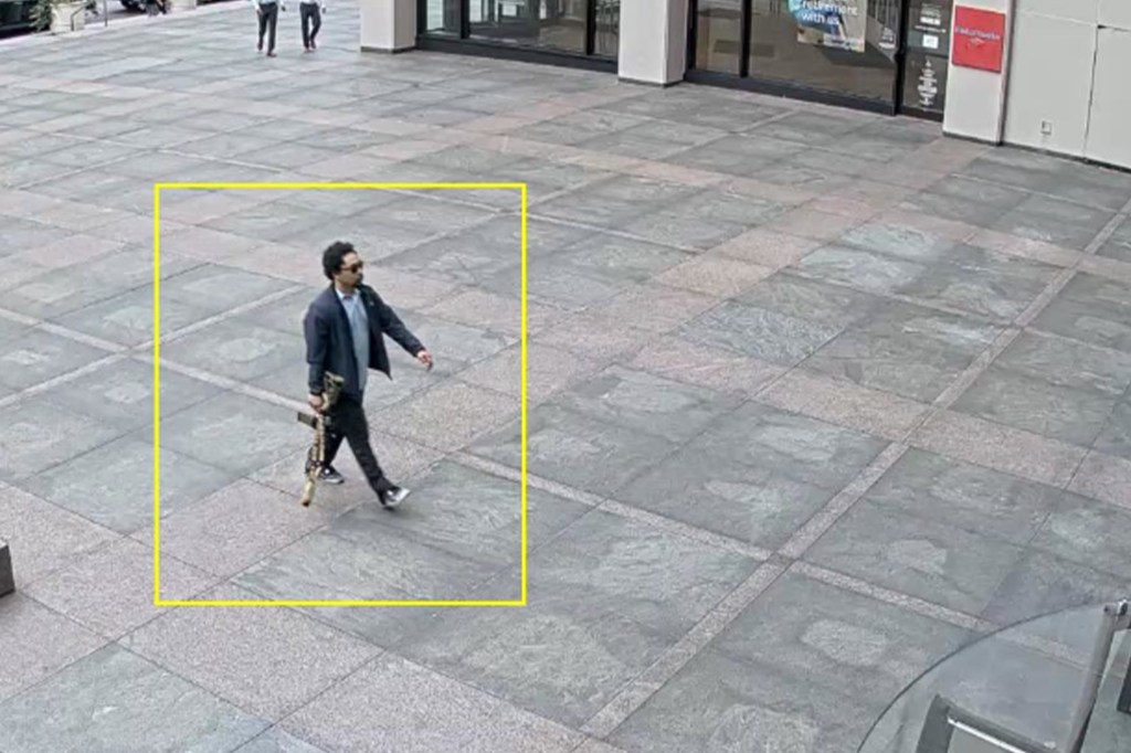 Security camera image of a man carrying a rifle on East 52nd Street.