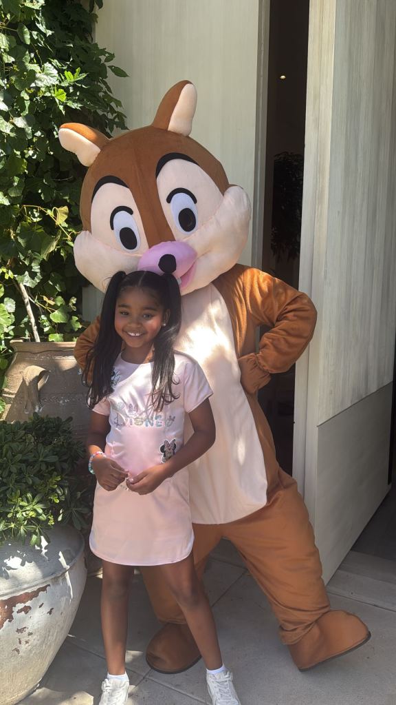 True Thompson posing with a Disney character.