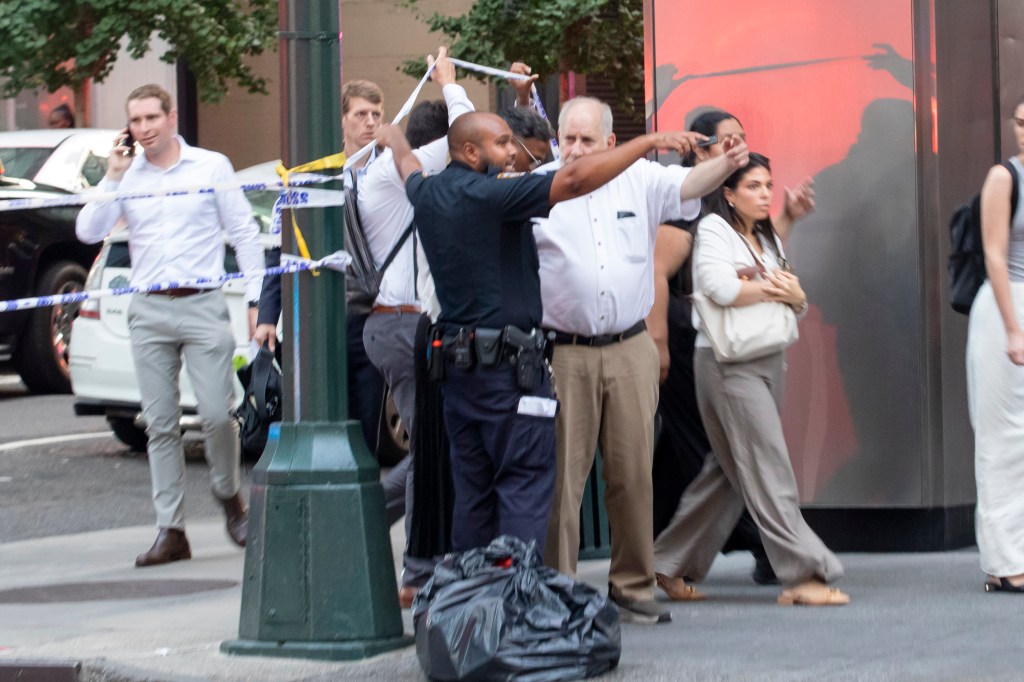 NYPD direct building occupants away from the scene of a shooting where a police officer was killed and at least 5 others were shot at 345 Park Ave in Midtown, Manhattan.