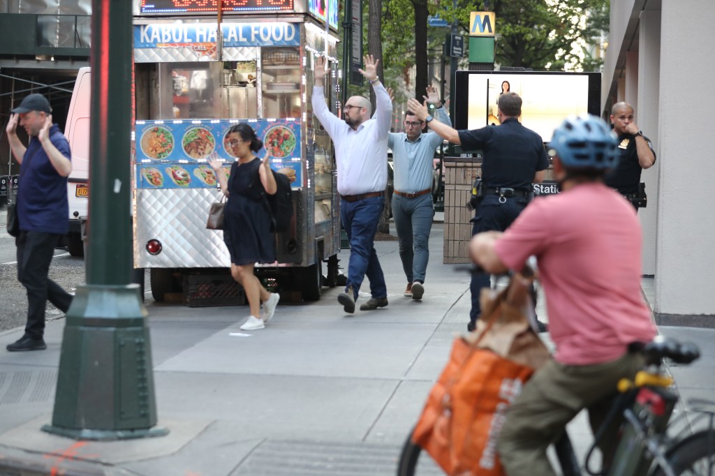 People with hands up walking away from police officers during an active shooter situation.