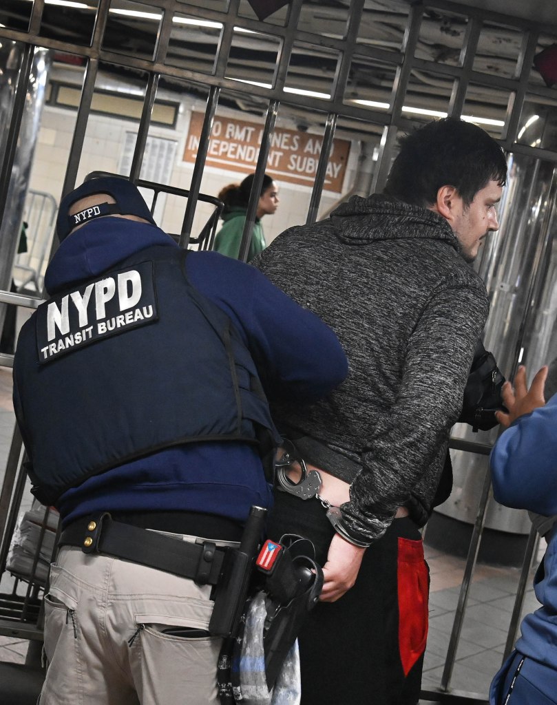 NYPD Transit Bureau officer arresting a farebeater in a subway station.