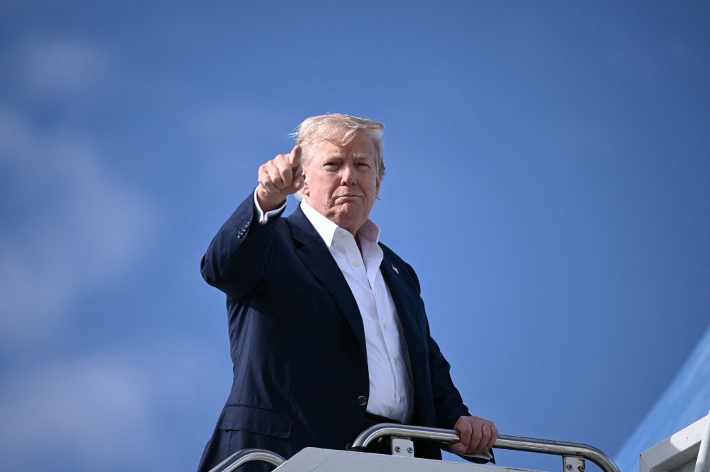 Donald Trump giving a thumbs up while boarding Air Force One.
