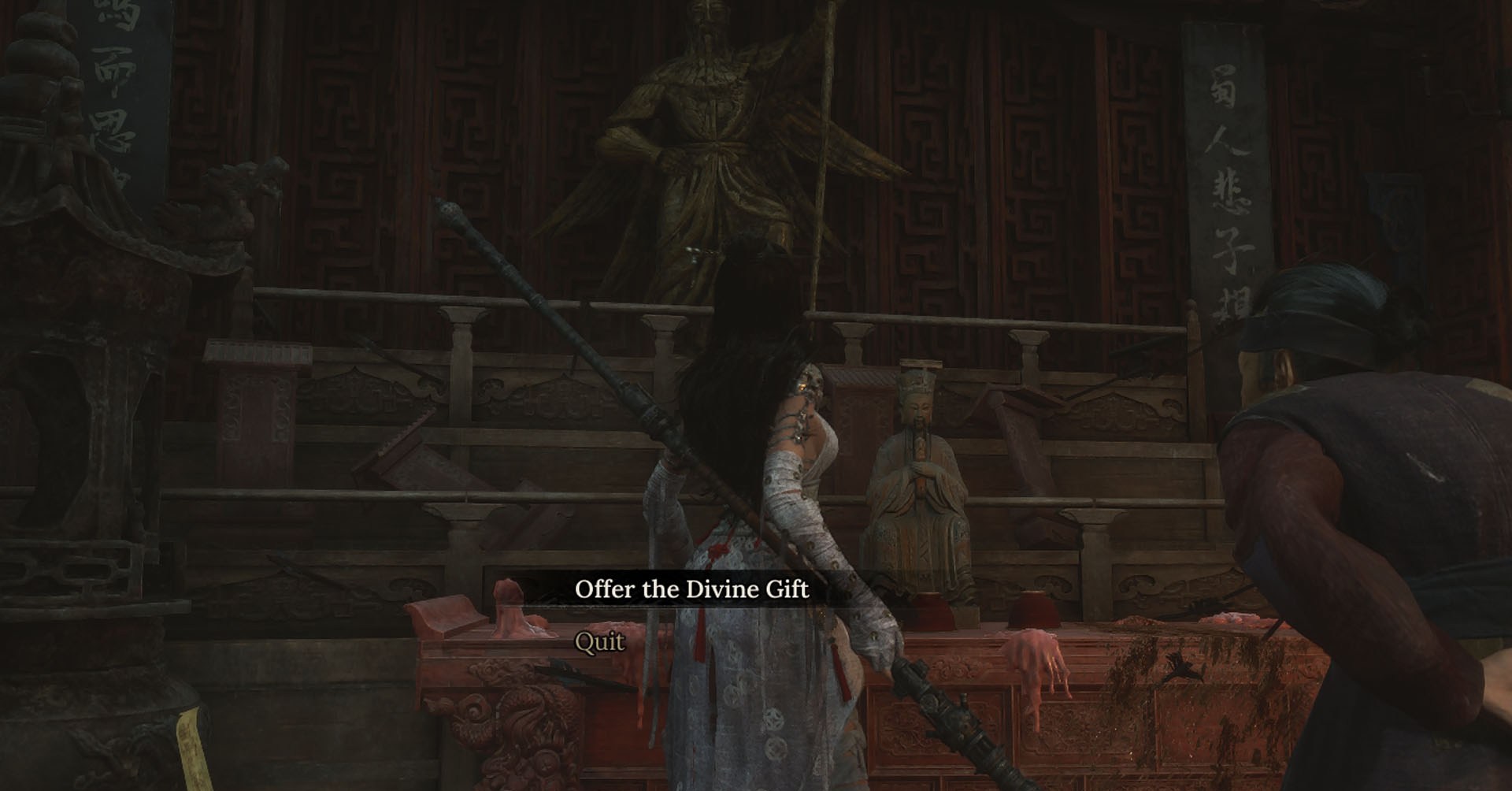 A Wuchang: Fallen Feathers screenshot showing the main character interacting with a statue. You can see a menu giving the player the option to offer the Divine Gift to the statue. There’s a old lady beside the main character.