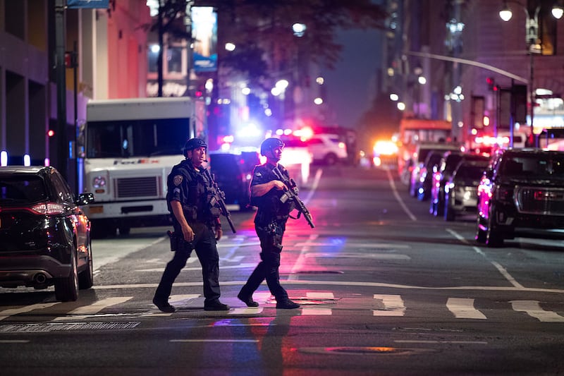 Police officers gather in a street as they respond to a shooting incident in the Midtown Manhattan neighborhood of New York on July 28, 2025 in New York City. Four people are dead after being shot during an active shooter incident in midtown Manhattan, including a police officer.
