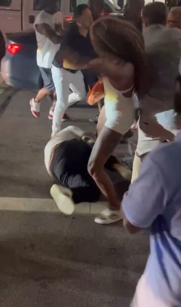 A person on the ground being attacked by a group of people.