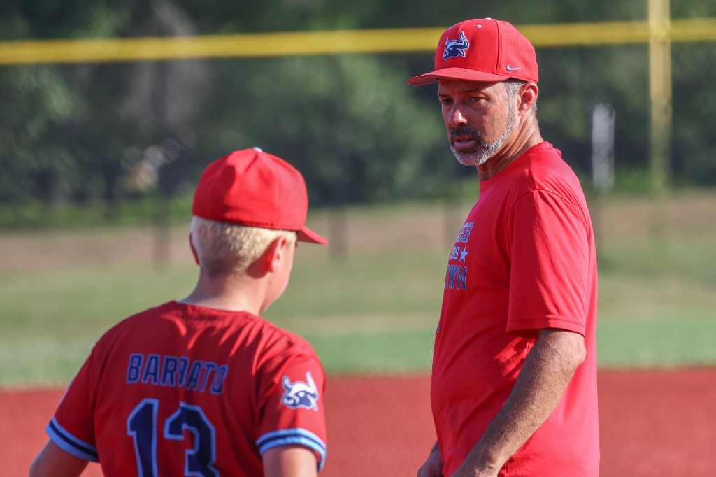 Baseball coach talking to player.