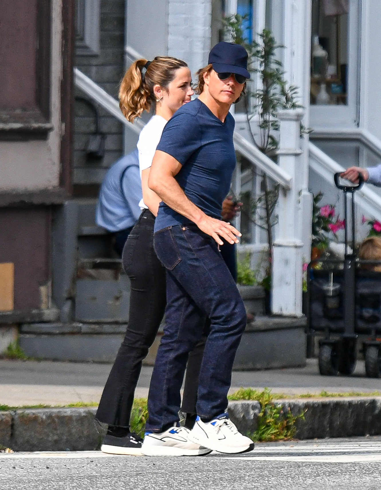 Tom Cruise and Ana de Armas holding hands outdoors. 