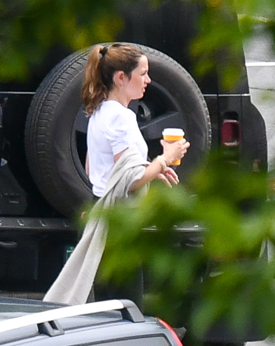 Ana de Armas carries a cup of coffee outdoors.