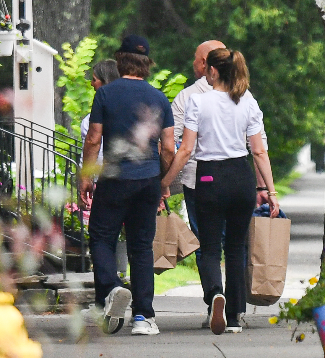 Ana de Armas and Tom Cruise hold shopping bags and hold hands. 