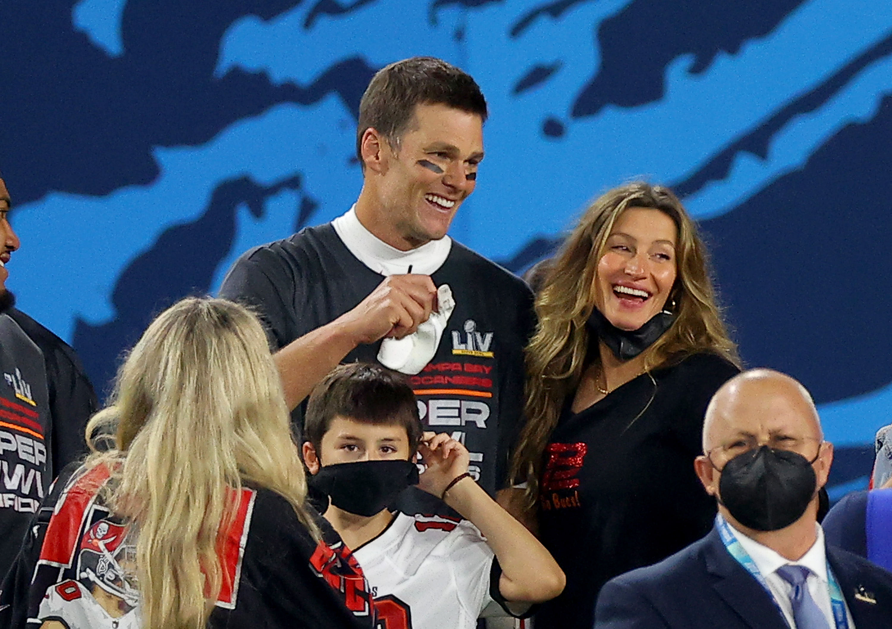 Tom Brady and Gisele Bündchen on a football field with their son. 