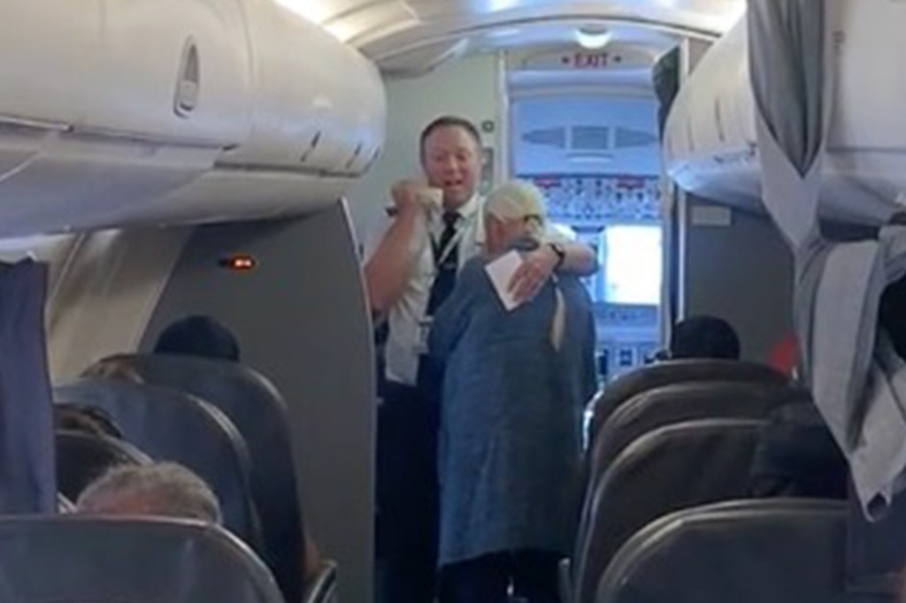 Pilot hugging passenger on airplane.