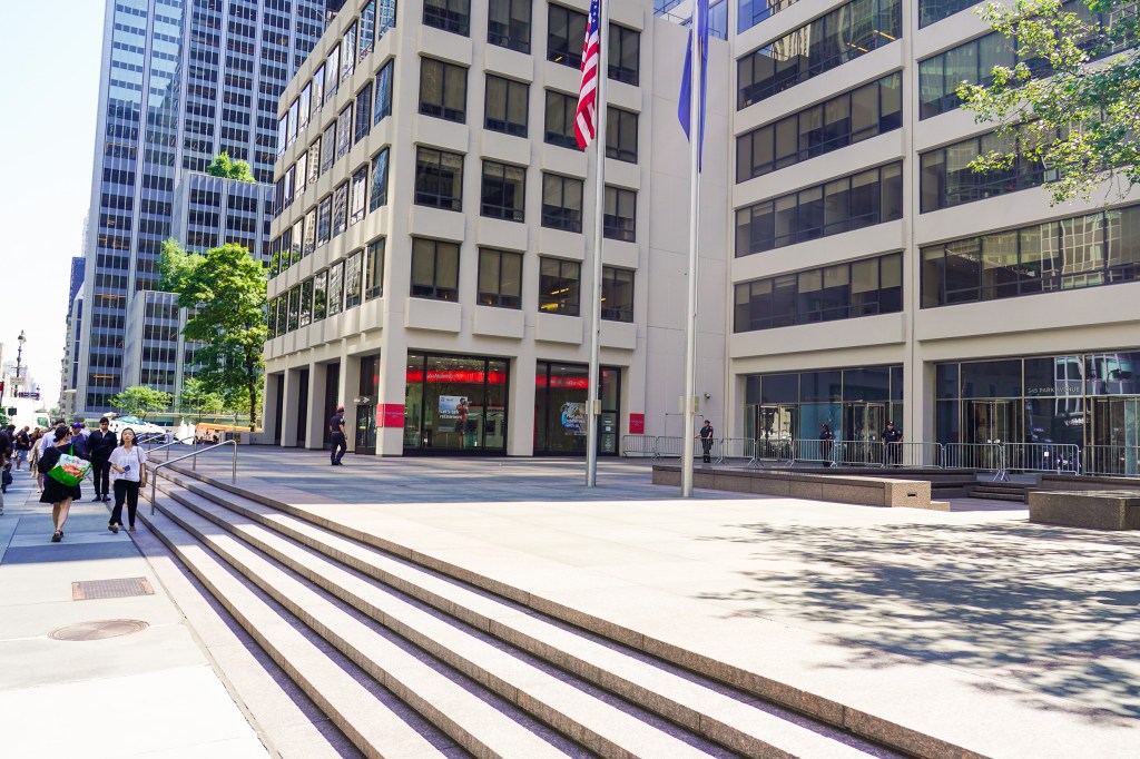Exterior of 345 Park Avenue in Manhattan following a mass shooting; police officers are visible.