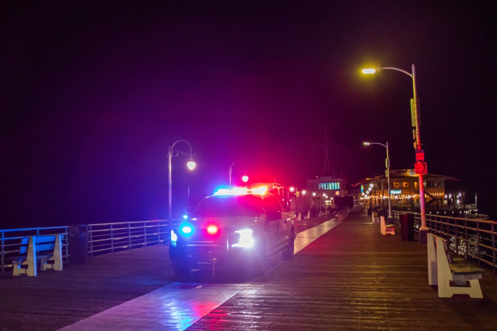 A police officer drives along the Santa Monica Pier warning people of the potential tsunami threat.